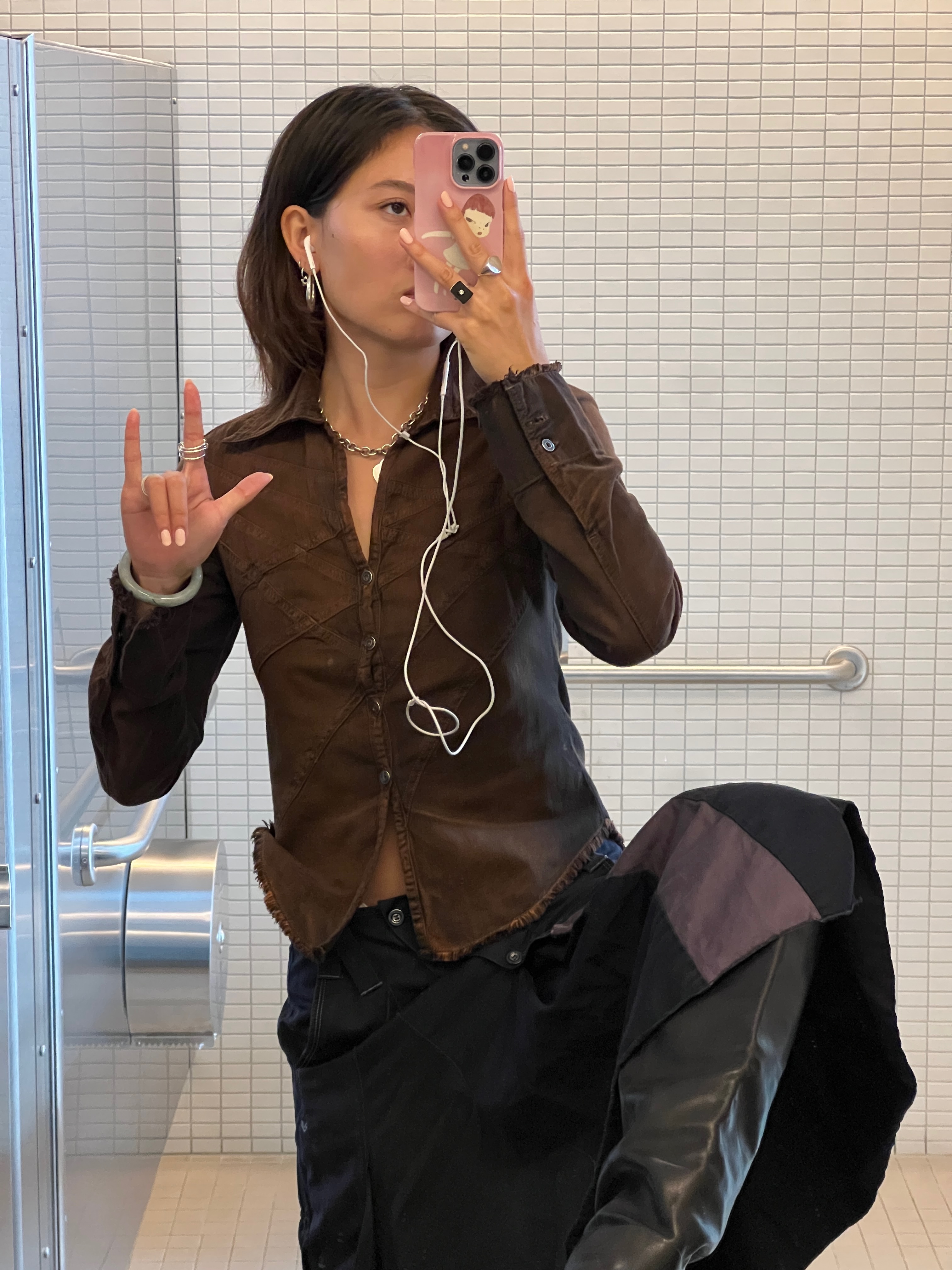 Vivian Li in a brown shirt and black skirt and black boots in a mirror selfie