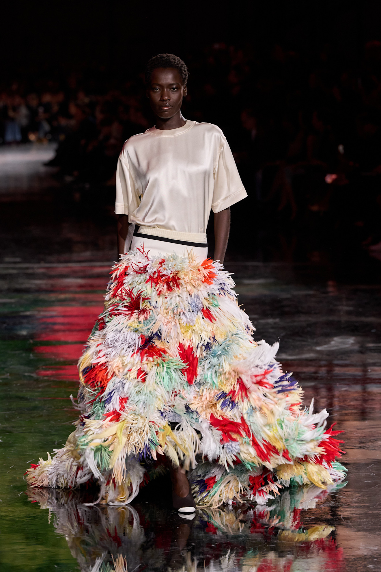 Spring/summer 2026 runway model in a silk top and feather skirt.