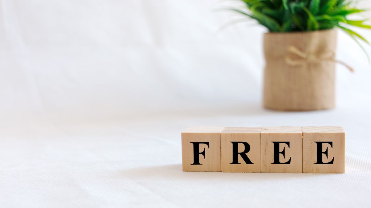 The word &#039;free&#039; on wooden blocks in front of a green plant