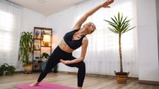Woman practicing yoga as a workout in her living room