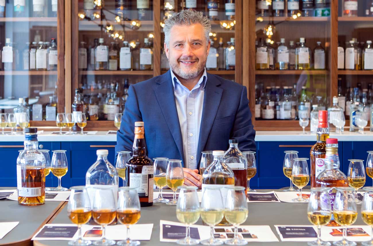 A man at a table with whisky glasses and bottles