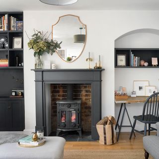 White living room with black fireplace and wood burner and a workspace in the curved alcove