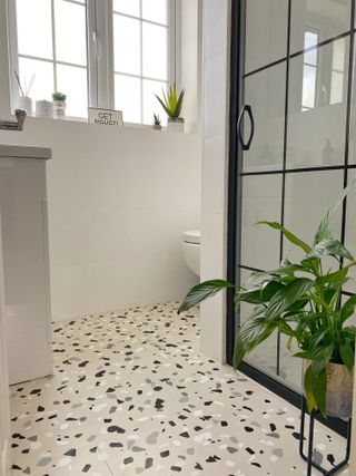 Beige bathroom tiles with terrazzo stencil in white and black pattern