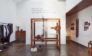 A full-size wooden loom and above, on the wall, the words "Gerd Hay-edie, evolutionary weaver, the story of Mourne Textiles"