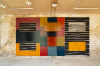 View of a large multicoloured piece by Sean Scully against a distressed wall at Château de Boisgeloup