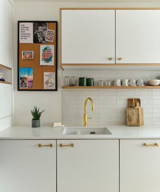 A white kitchen with gold cabinet hadware