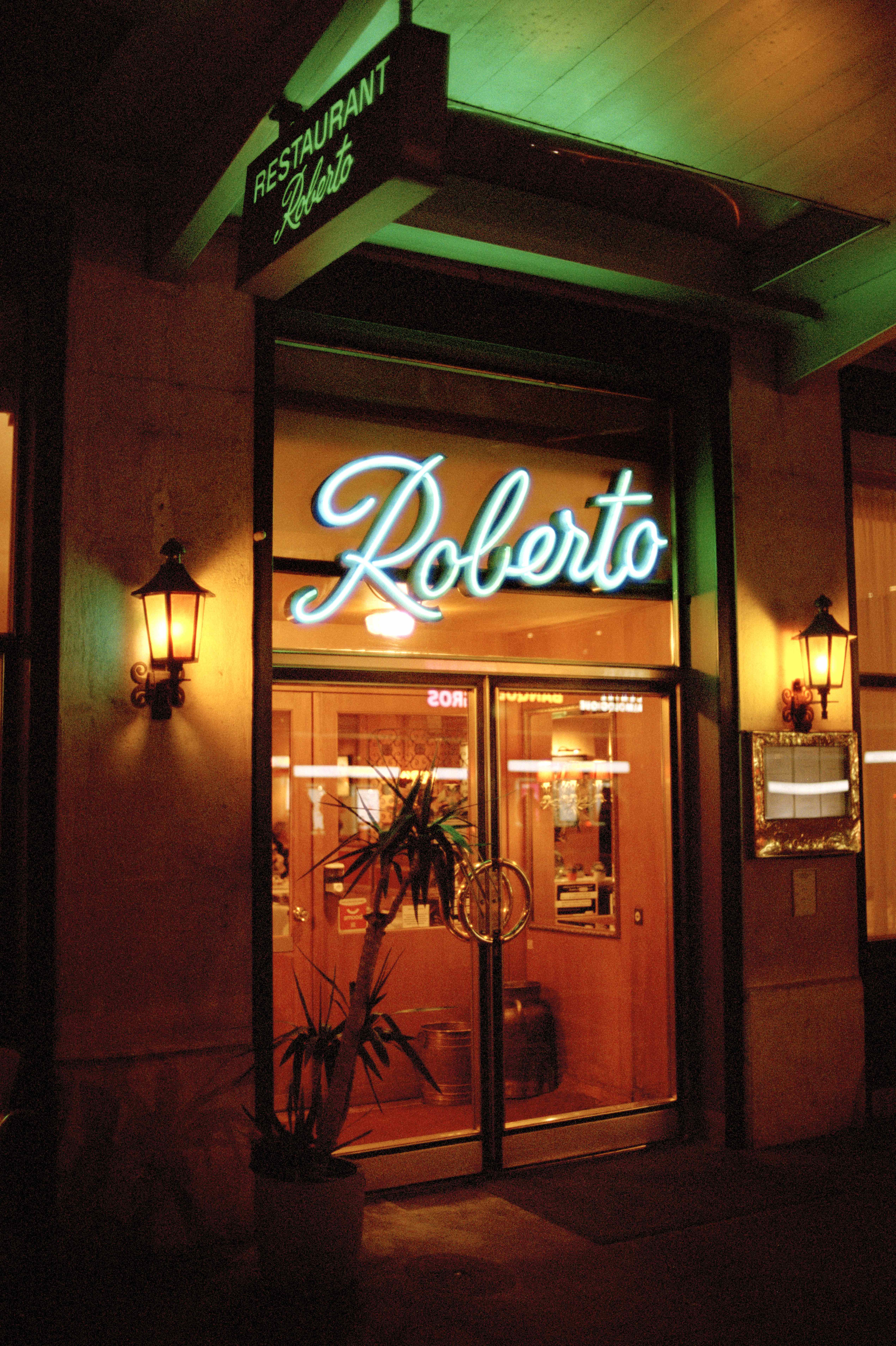 ‘roberto' in neon lights on restaurant door at night
