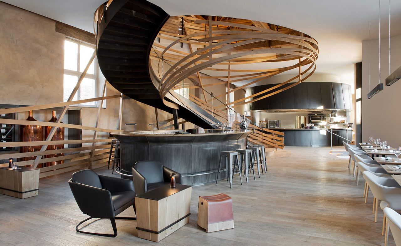 Dining room featuring a large spiral staircase with abstract curving wood panels