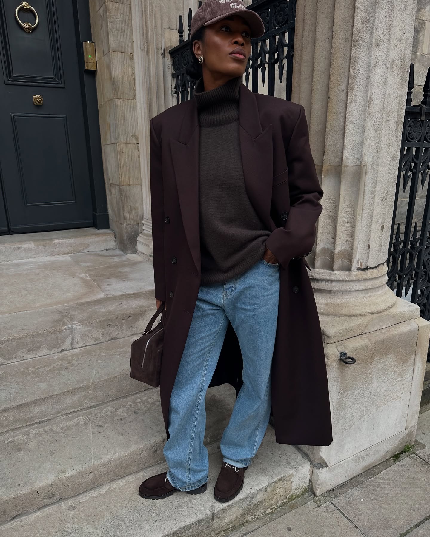 Marilyn NK wearing a brown cashmere knit, blue jeans and brown loafers.