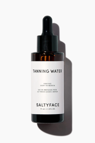 A bottle of Saltyface Tanning Water set against a white background.