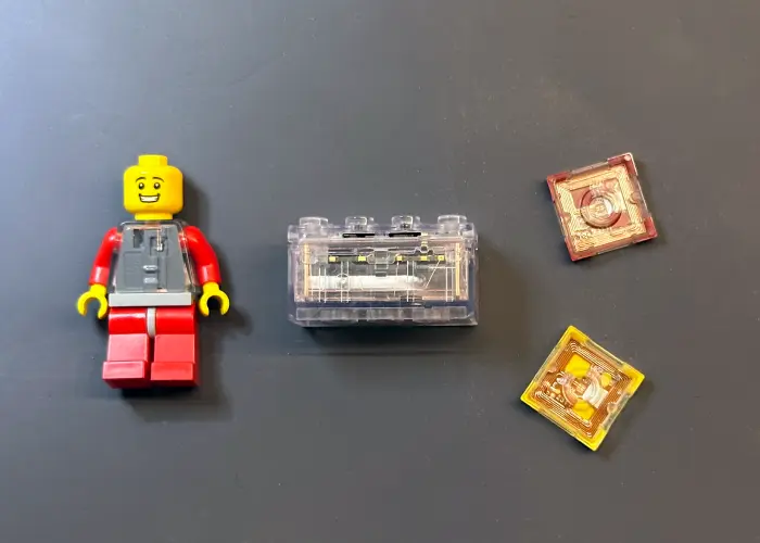 A LEGO Smart Play brick alongside two Smart Tags and a Smart Minifigure