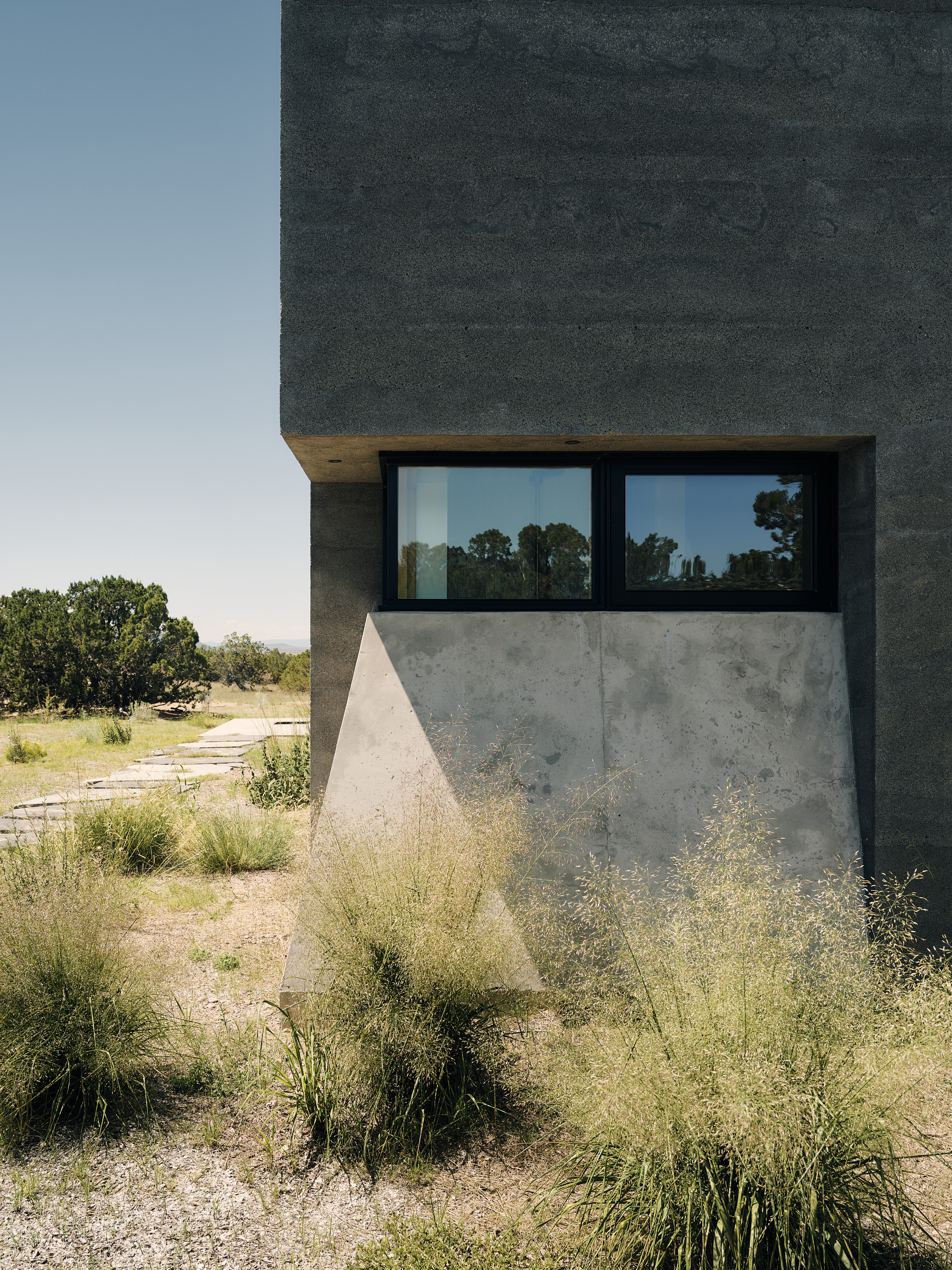views of Sombra de Santa Fe, new mexico house, with dark, minimalist geometric volumes and clean walls and long nature views