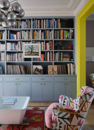 Yellow and grey living room with accent chair and built in bookcase