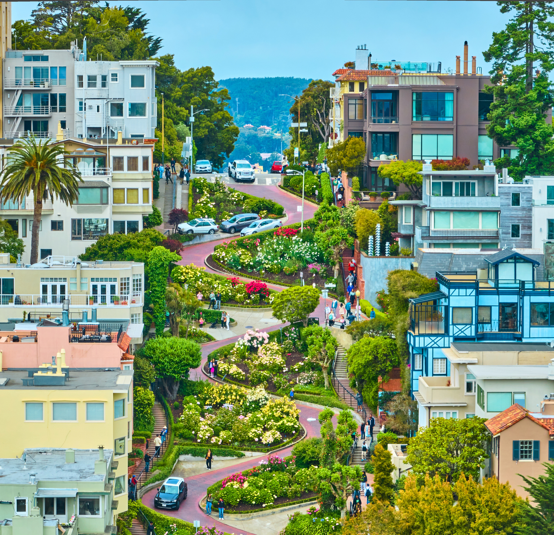 Image of Panorama Lombard Street aerial of cars and people winding down iconic hill beside buildings