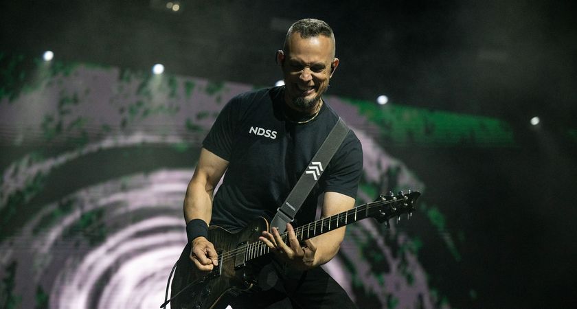 Mark Tremonti grimaces (or smiles?) as he plays a solo during a 2025 live show with his PRS signature guitar.