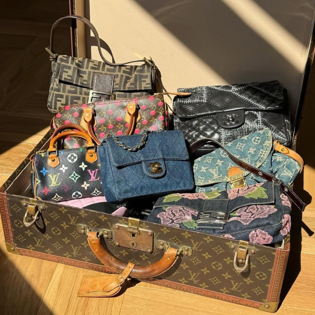 a louis vuitton trunk filled with vintage designer handbags
