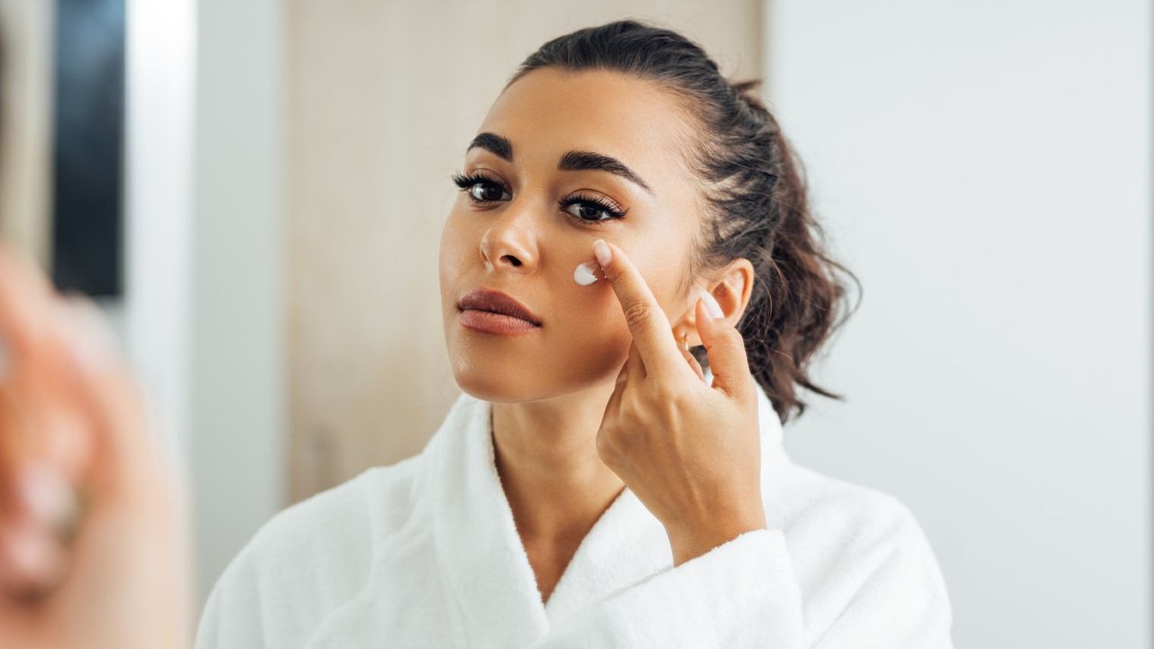 Woman Applying Moisturizer On Face