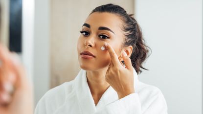 Woman Applying Moisturizer On Face