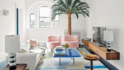 Small living room with pink chairs and floating TV unit