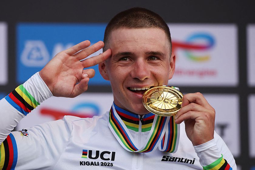 Gold medallist Belgian rider Remco Evenepoel bites on his medal on the podium following the men&#039;s Elite Individual Time Trial cycling event during the UCI 2025 Road World Championships, in Kigali, on September 21, 2025. (Photo by Anne-Christine POUJOULAT / AFP)