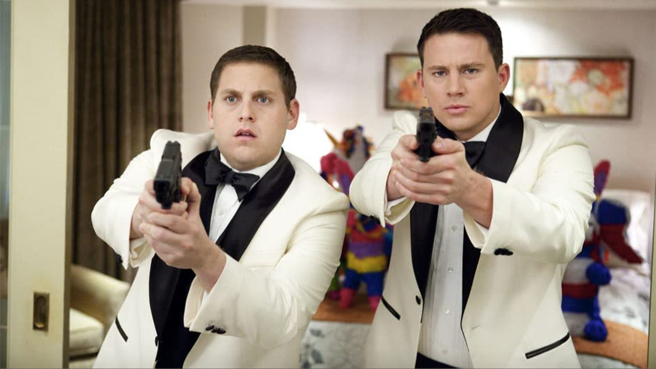 Jonah Hill and Channing Tatum shoot guns, in tuxedos, at 21 Jump Street.