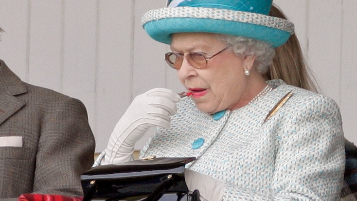 Queen Elizabeth II applies her lipstick as she attends the annual Braemar Gathering and Highland Games 2011
