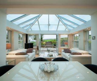 white modern conservatory with cream contemporary furniture and gloss finishes