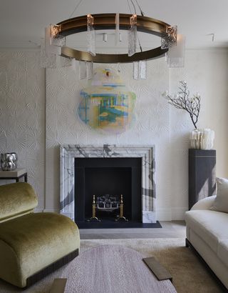 neutral living room with marble fireplace and yellow armchair
