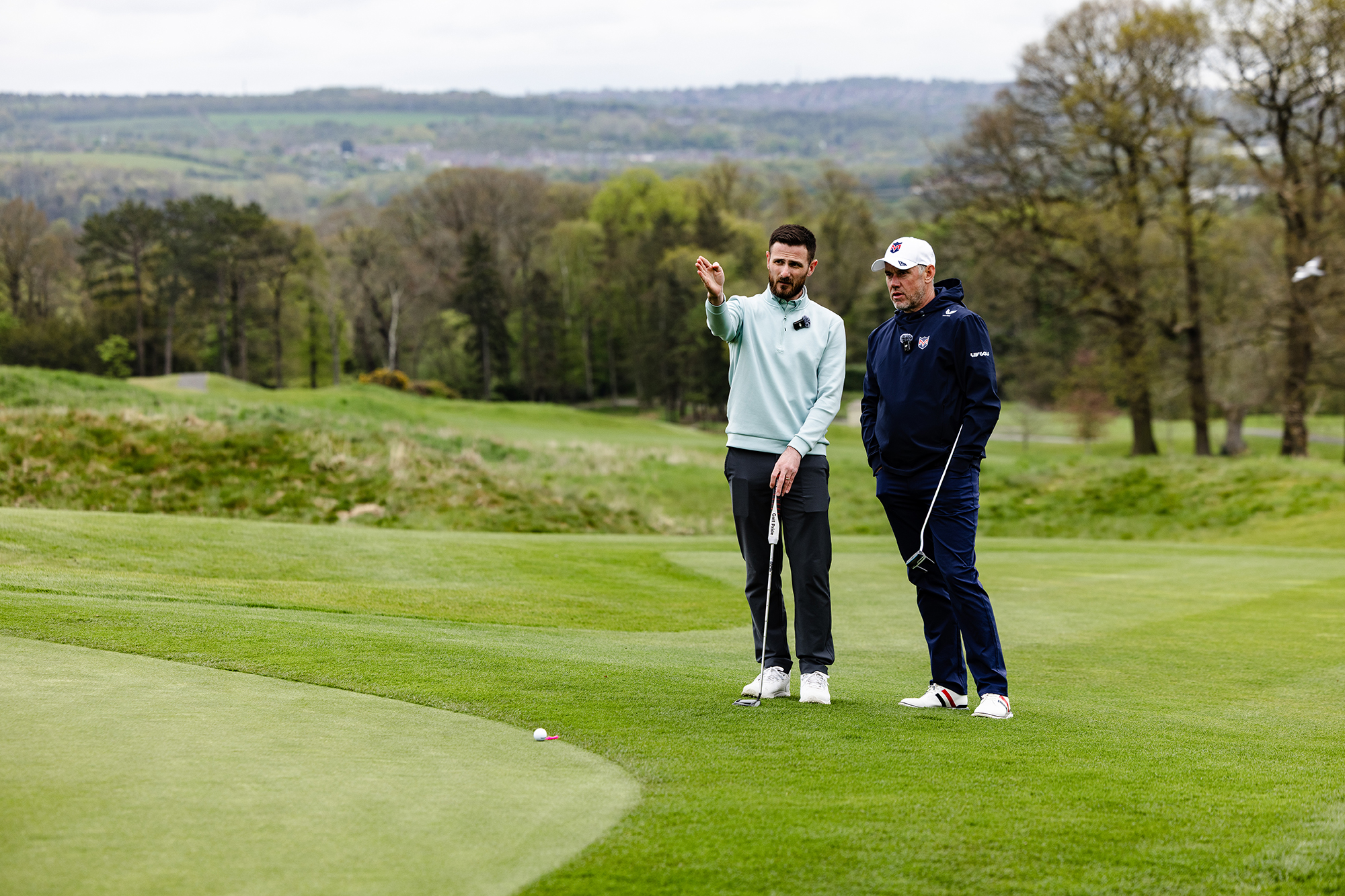 Lee Westwood and Baz Plummer discussing a putting strategy next to the green