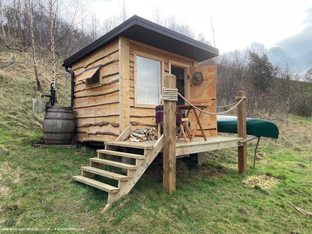 One of last year's entries is a wooden outhouse with stairs surrounded by a green hill