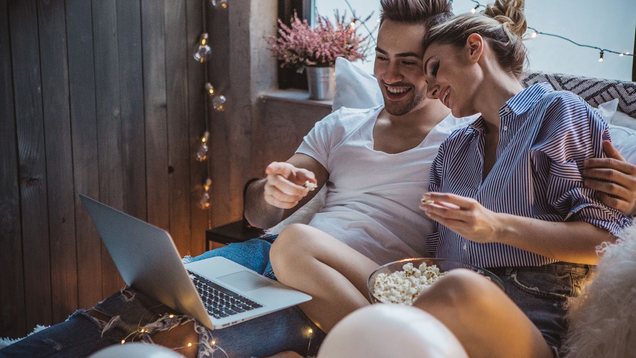 Couple on Valentine&#039;s Day looking at a laptop for tech shopping