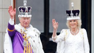 King Charles III and Queen Camilla wave from the balcony of Buckingham Palace, whilst watching an RAF flypast, following their coronation