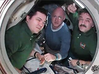 Expedition 26 crew members (from left) Oleg Skripochka, Scott Kelly and Alexander Kaleri bid farewell from inside the Soyuz TMA-01M spacecraft before closing the hatches on March 15, 2011. The crew landed on Earth on March 16.landed
