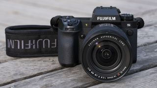 The Fujifilm X-H2S, one of the best mirrorless cameras, sitting on a wooden bench