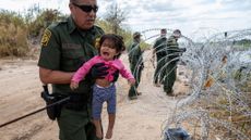 U.S. Border Patrol agent helps young girl through Texas razor wire
