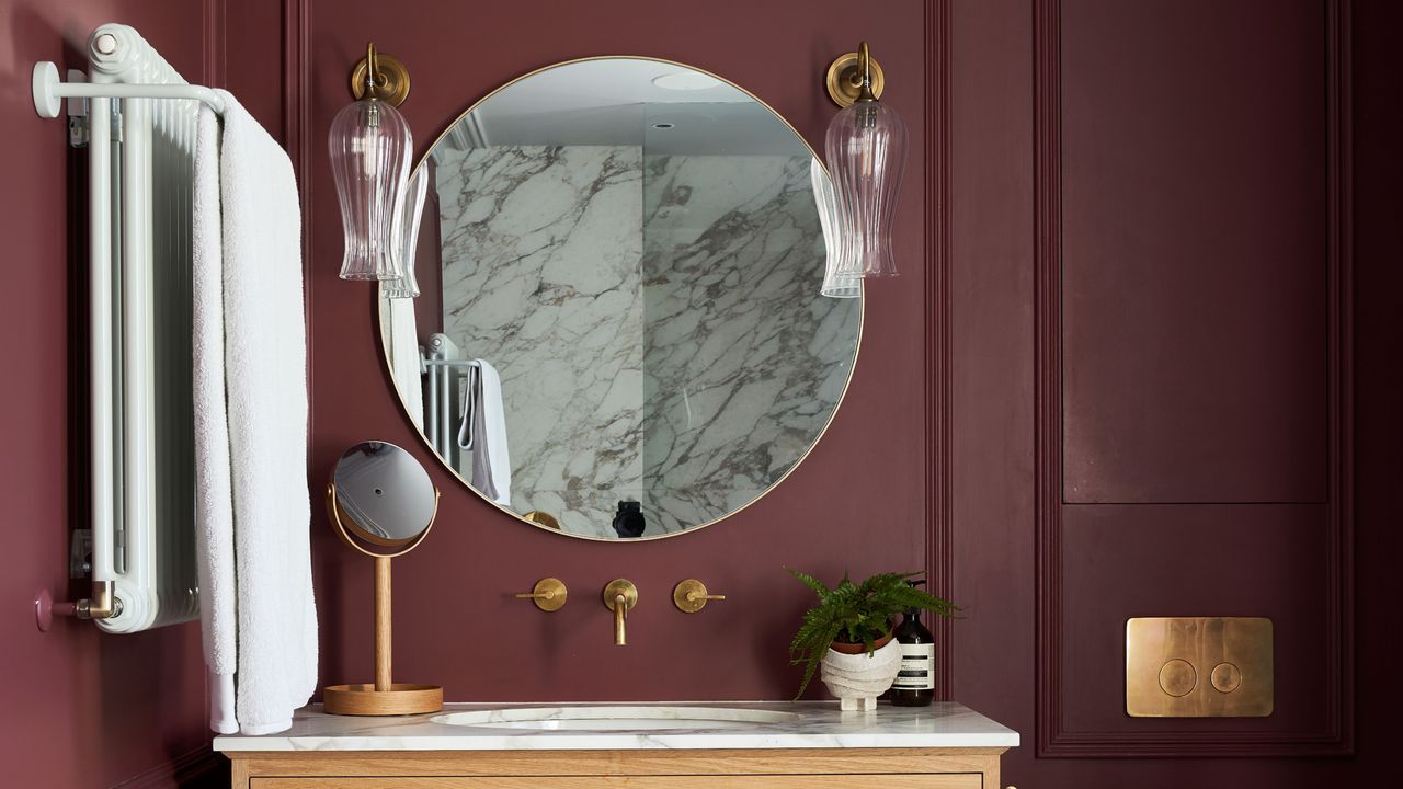 Bathroom with maroon wood panelled walls, grey and white marbled floor, handbasin in wooden chest of drawers vanity unit