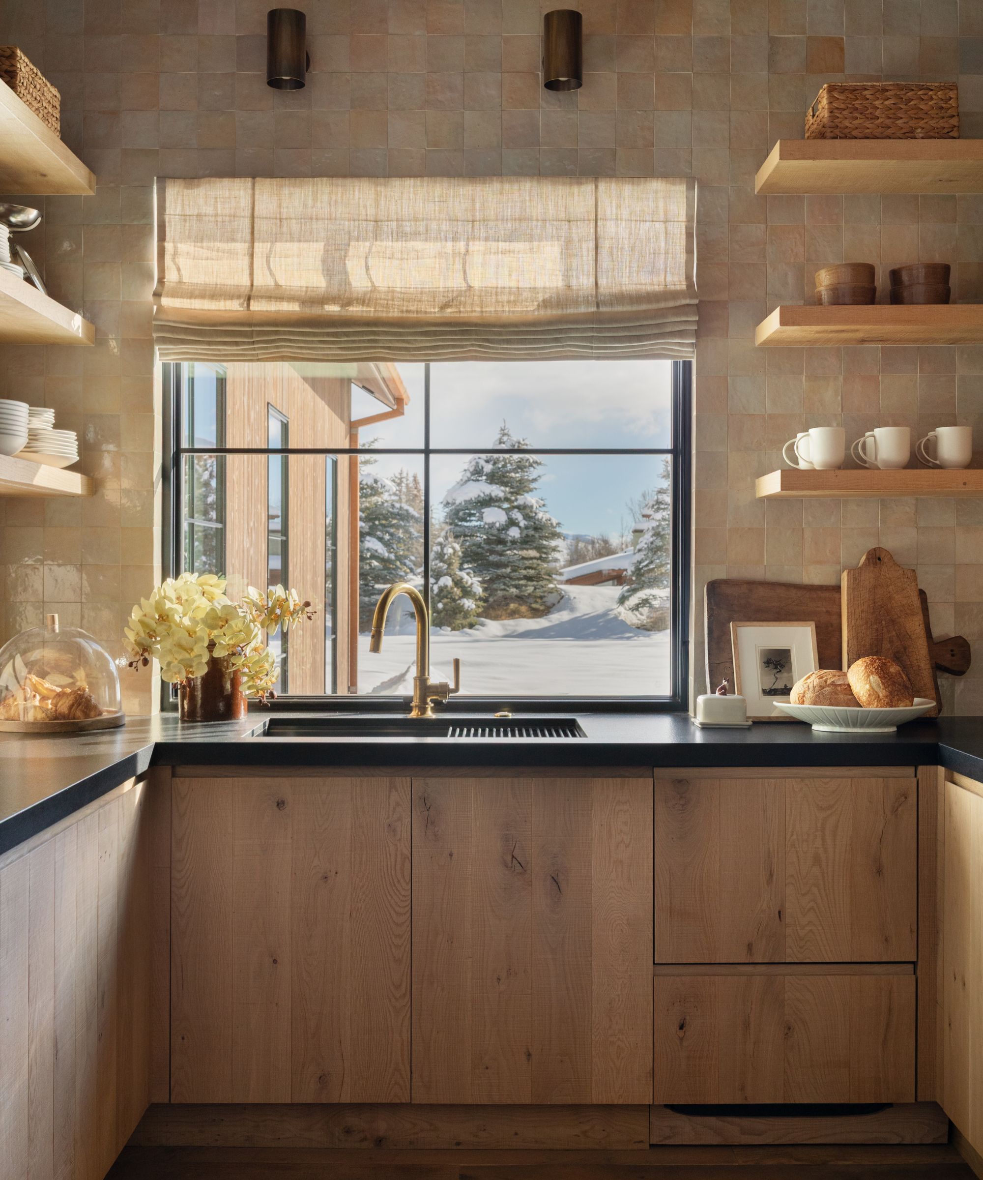a warm neutral modern pantry in a mountain home with zellige tiles, oak cabinetry and open shelving