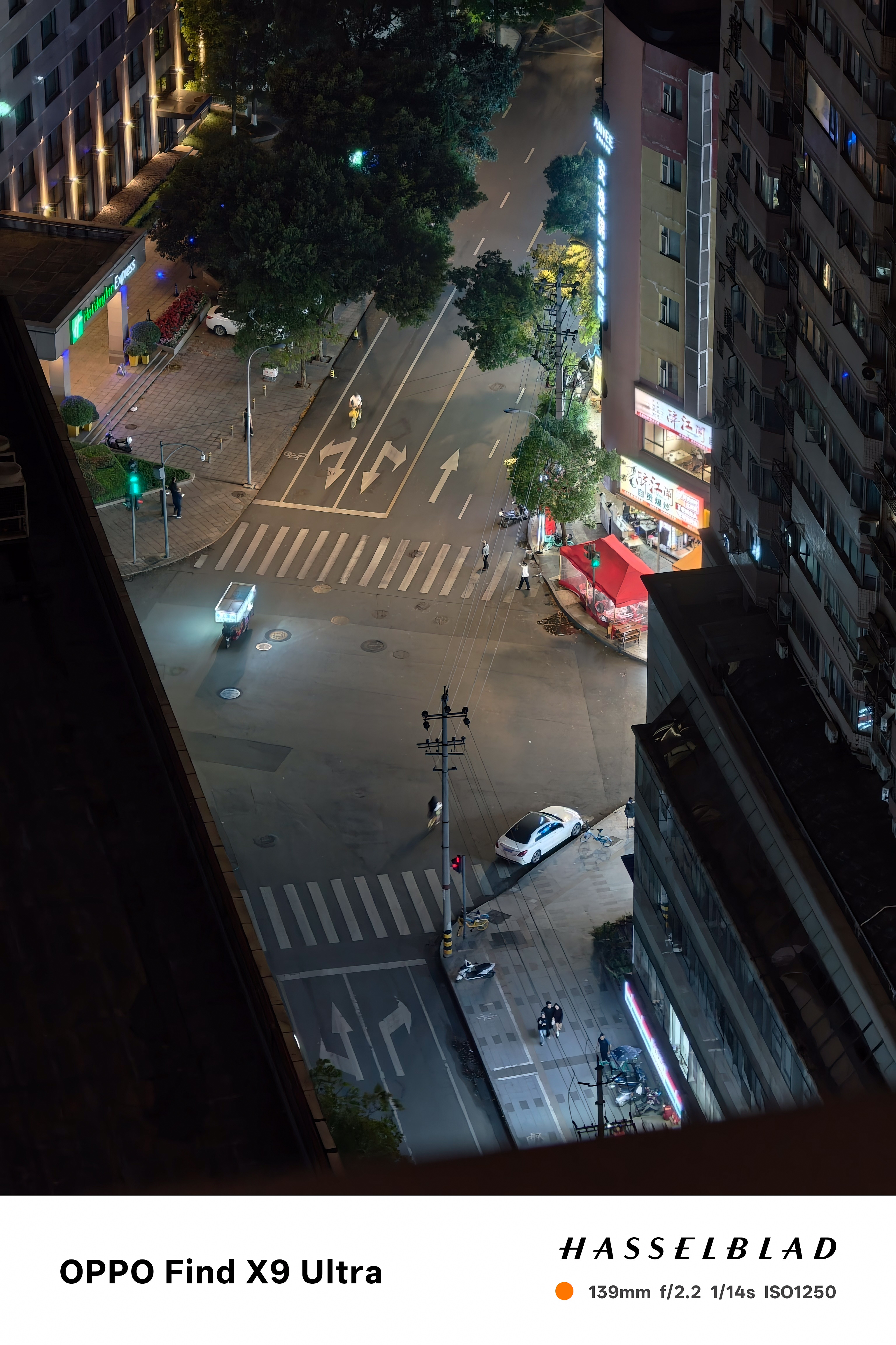 Nighttime aerial view of a quiet city intersection between tall apartment buildings