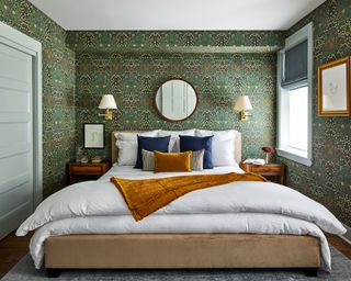 A bedroom color idea with green floral wallpaper, and blue and yellow velvet bedding