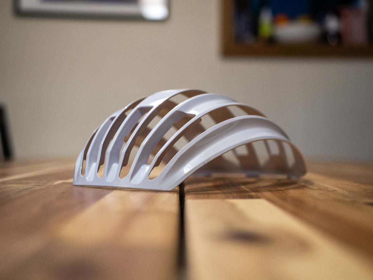 A white Uvex Surge helmet stands on a wooden table