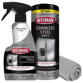 A spray bottles of Weiman stainless steel cleaner with a packet of wipes and microfiber cloth