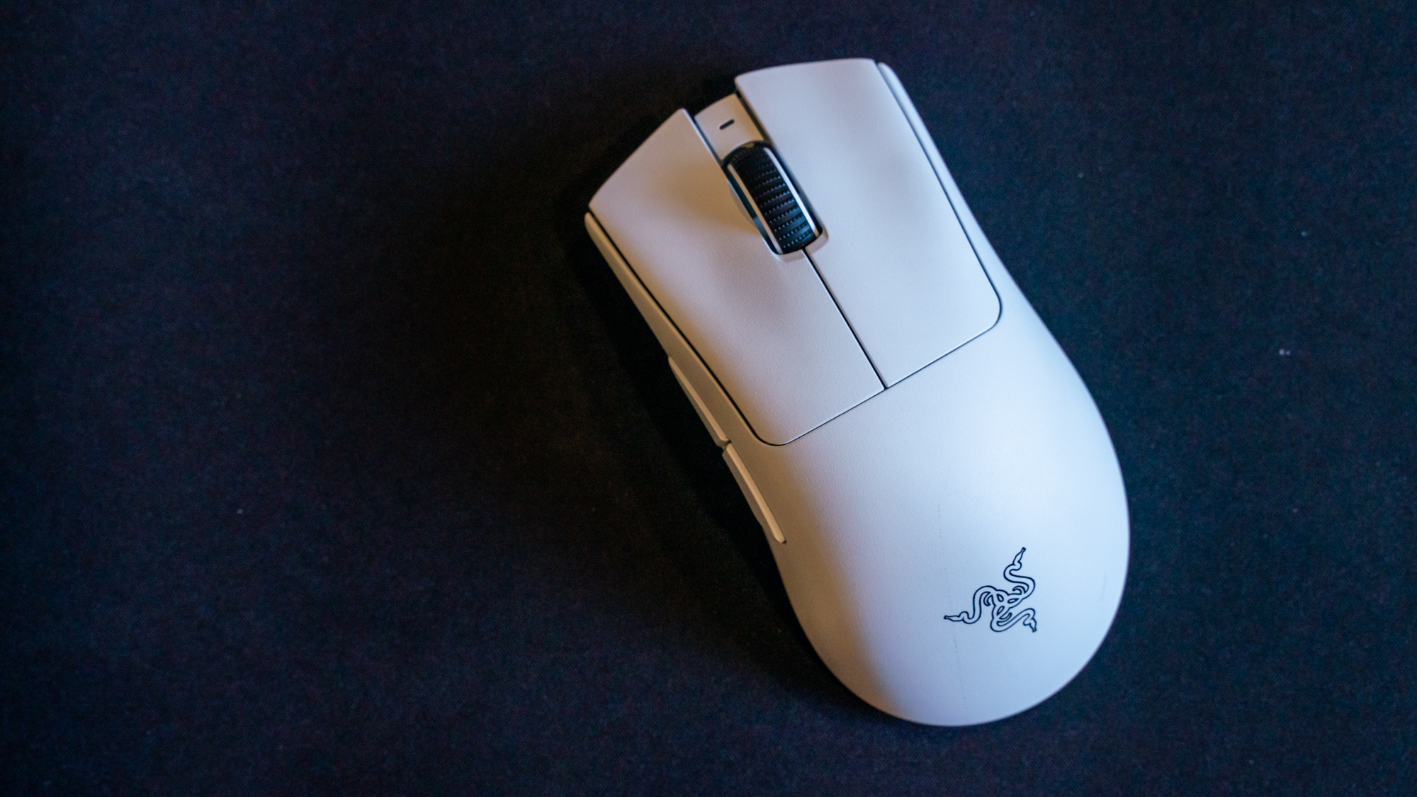 En hvit gaming-mus av typen Razer Deathadder V3 Pro på en mørk musematte.