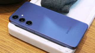 Samsung Galaxy S24 Plus i lila ligger med baksidan vänd uppåt.