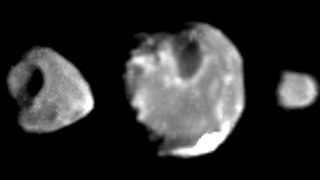 Three irregular shape grey moons side by side. Jovian moon Amalthea (center) Thebe (left) and Metis (right).