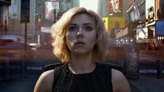 Scarlett Johansson sits in the middle of a very busy Times Square in Lucy.