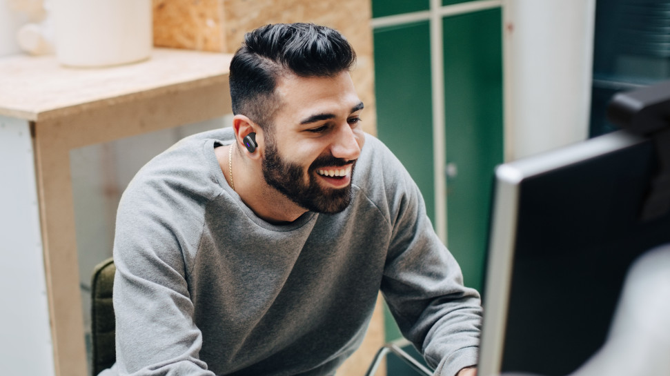 Man using Logitech Zone True Wireless earbuds for work