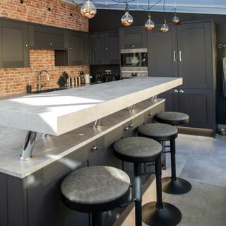 charcoal kitchen island with raised bar and black bar stools