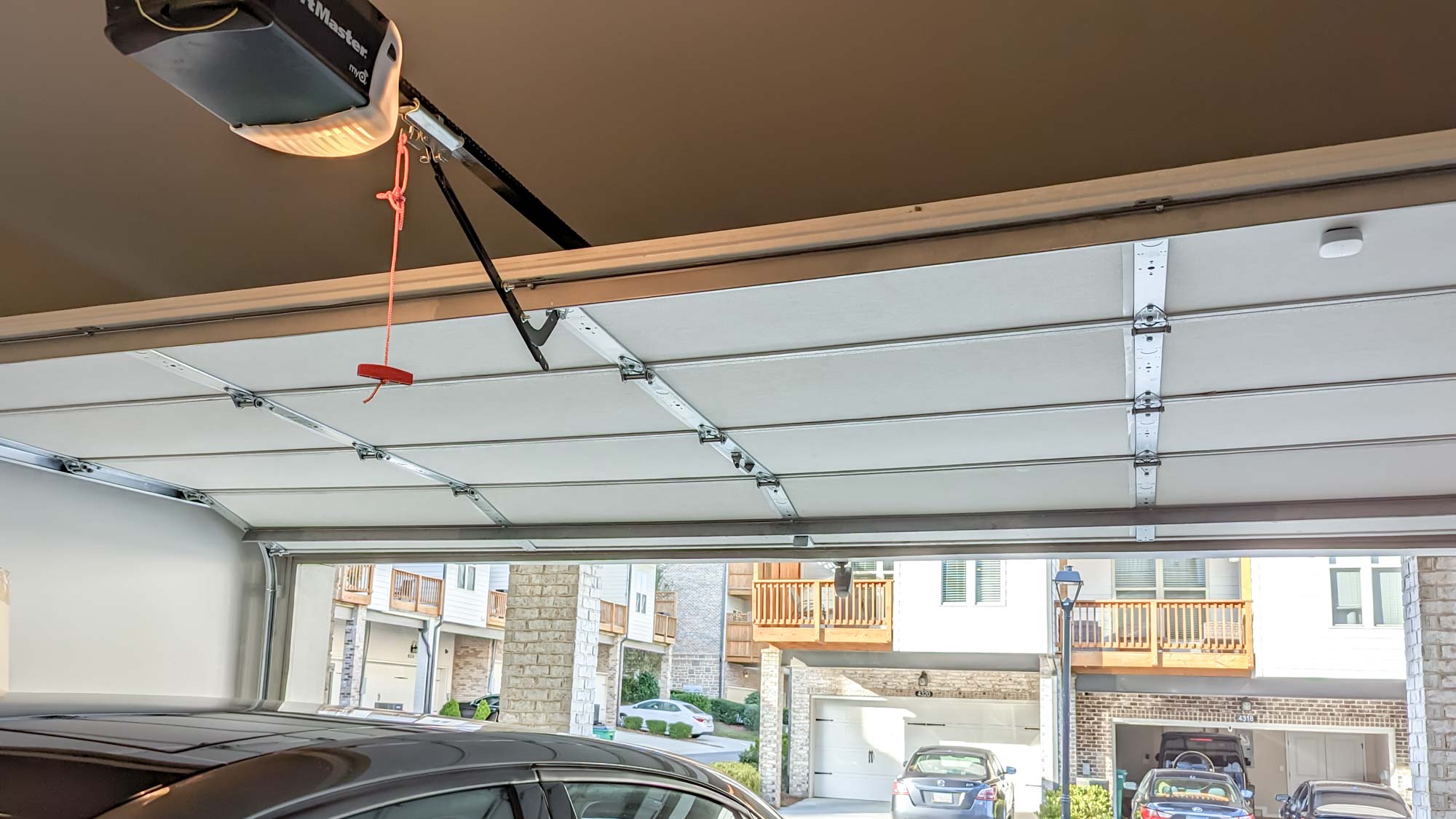 Picture of an open garage door with a car parked inside