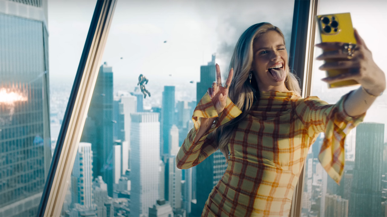 Eve Teschmacher posing for a selfie with her tongue out as the Hammer of Boravia attacks a skyscraper in Superman