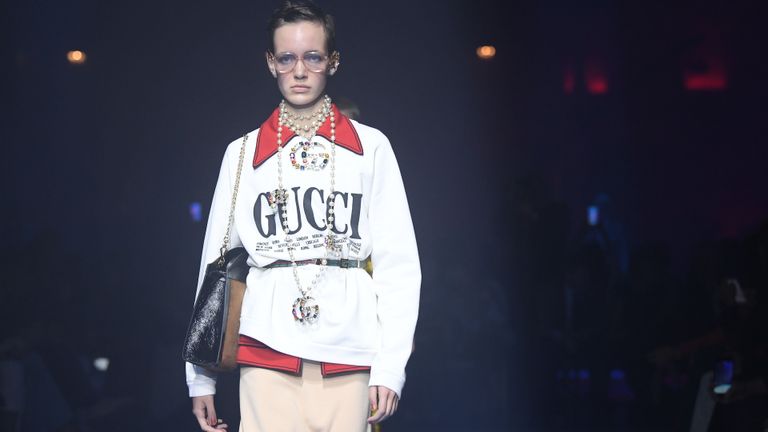 A model walks the runway in Gucci clothing.
